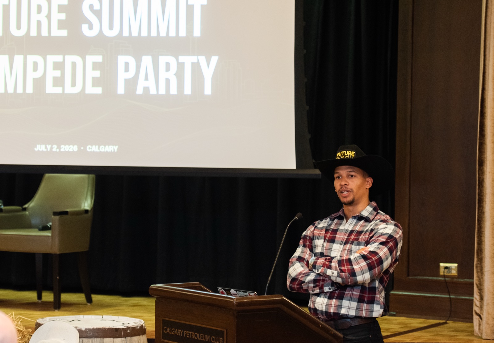 Josh Rainbow speaking at the podium at the Calgary Petroleum Club